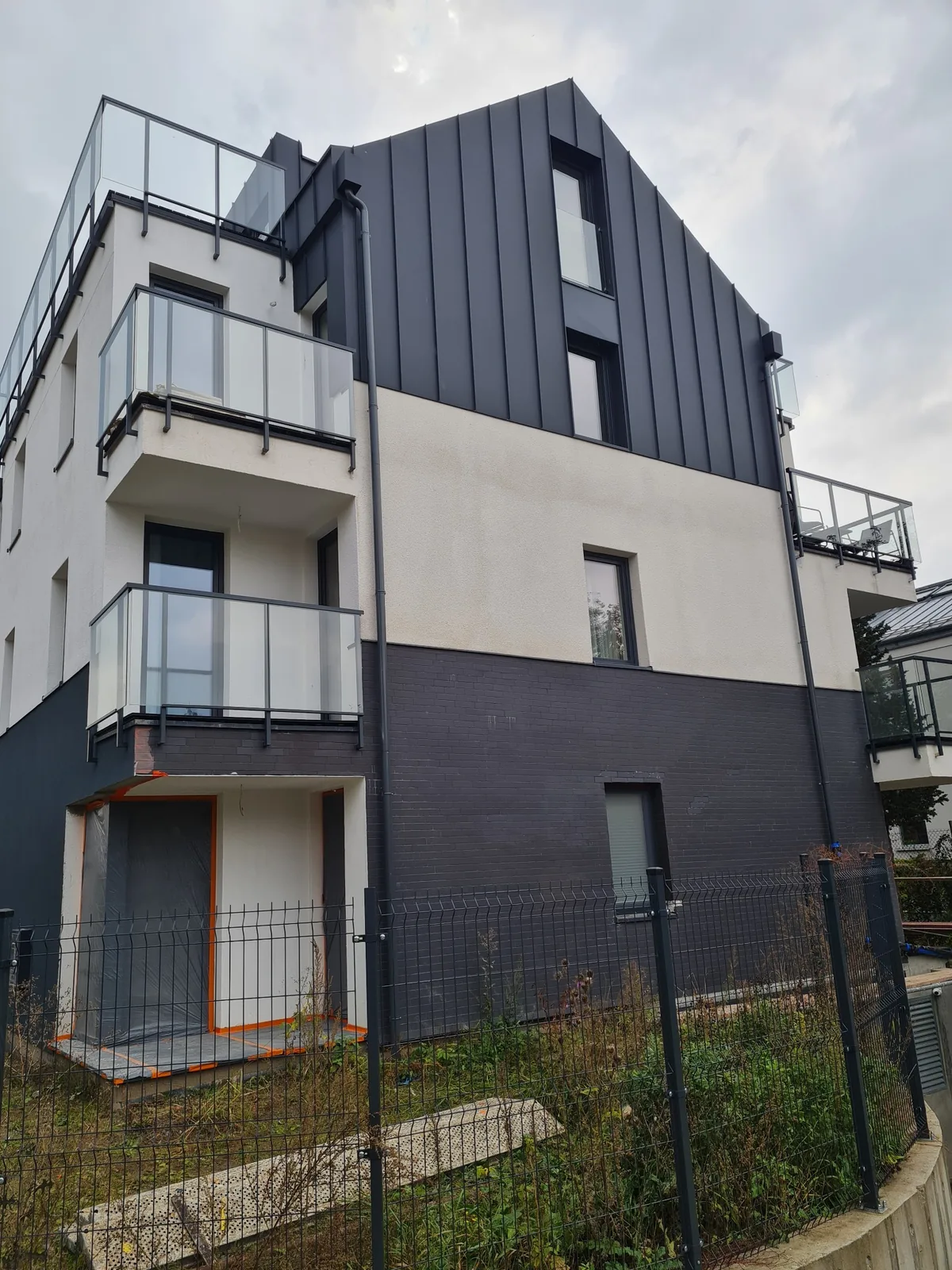 Elewacja budynku wielorodzinnego — grafit i biel
