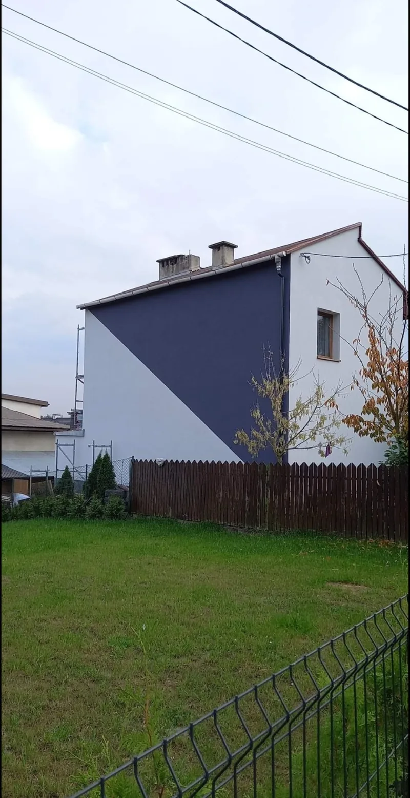 Szczyt domu — granatowa okładzina i biały tynk